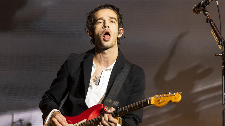 Matty Healy playing guitar onstage