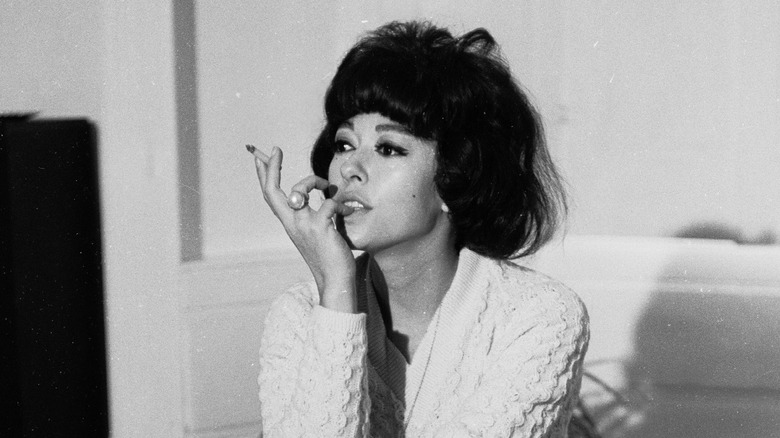 Rita Moreno smoking cigarette seated