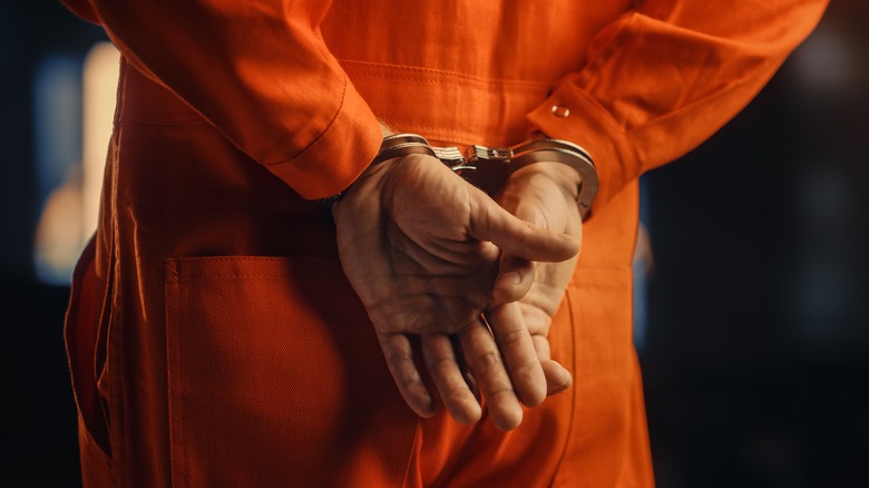 man handcuffed orange jumpsuit