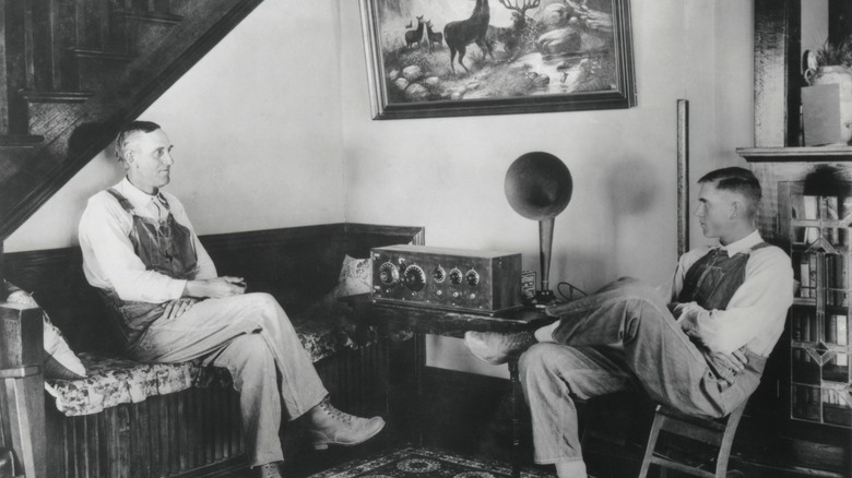 Two farmers listen to a radio