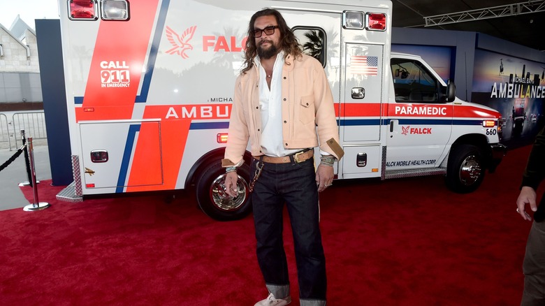 jason momoa posing in front of an ambulance