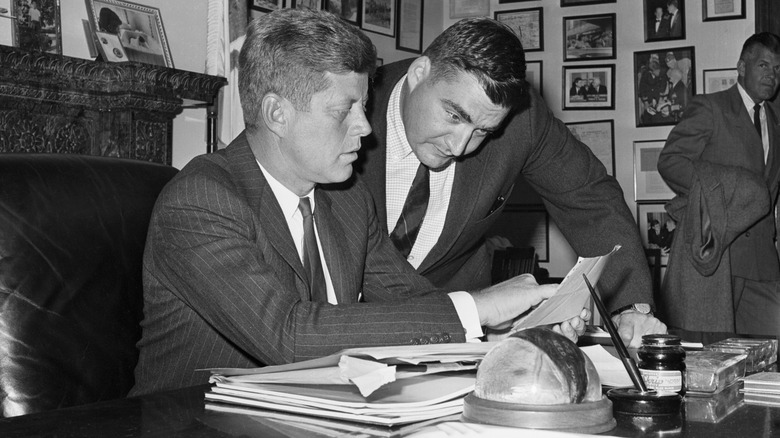 JFK and assistant checking documents