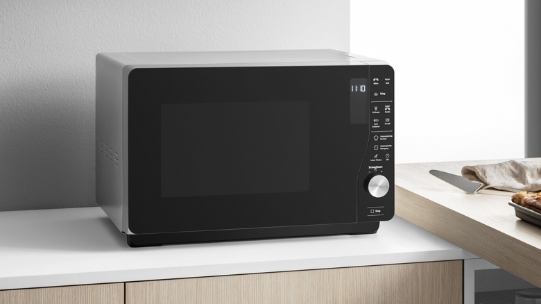 black microwave oven in a grey kitchen