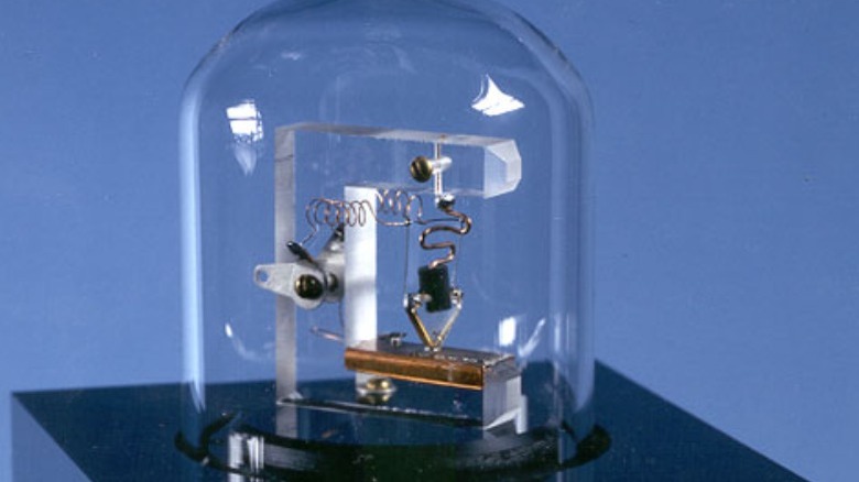 replica of the first point-contact transistor against a blue background, featuring wires and the germanium crystal