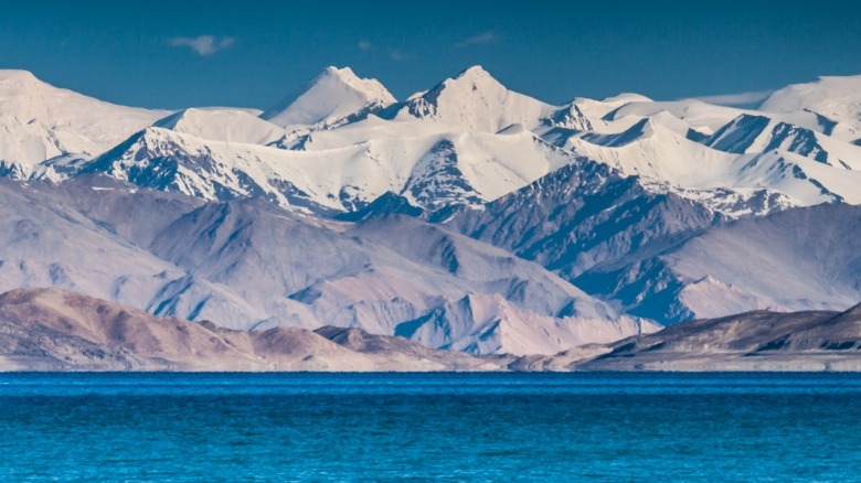 High snow-capped mountains with blue lake in foreground