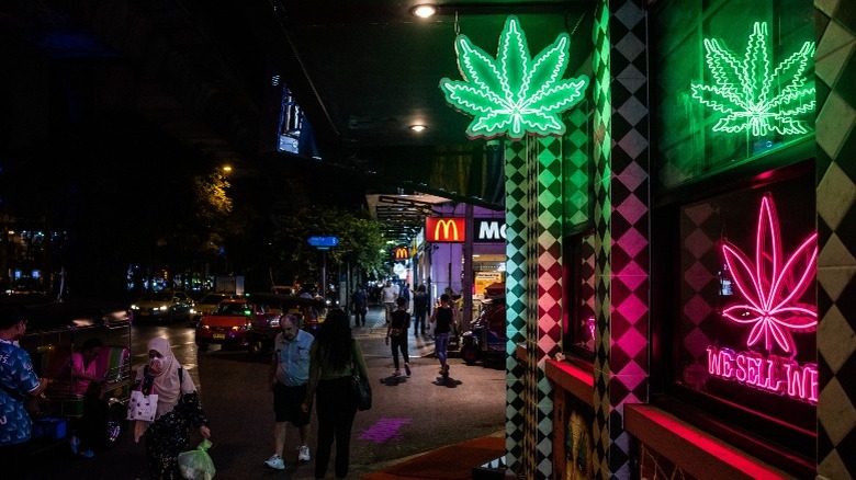 Dispensary storefront with green red neon signs at night