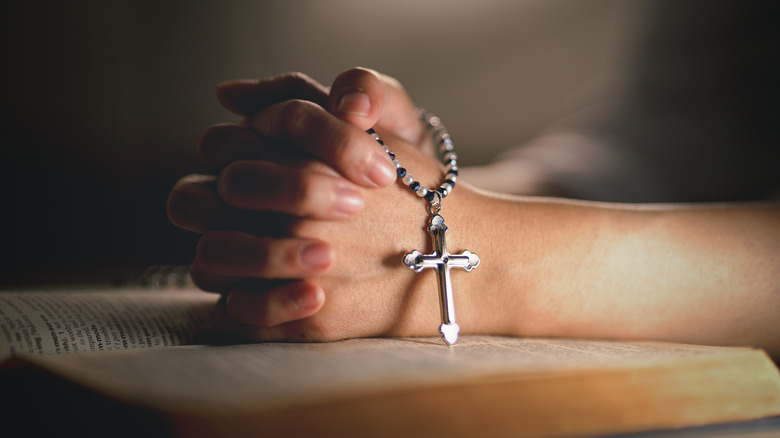woman praying and holding a rosary