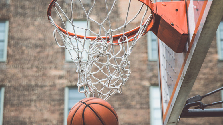 A basketball passing through hoop