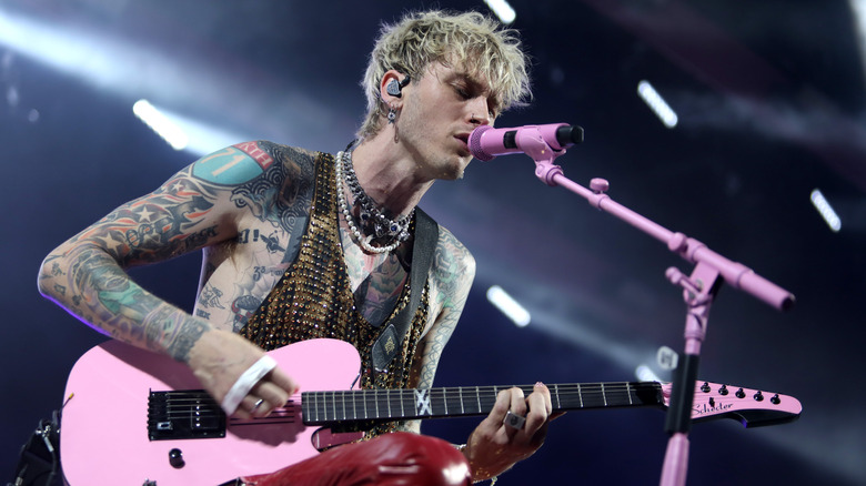 Machine Gun Kelly tattoos pink guitar performing