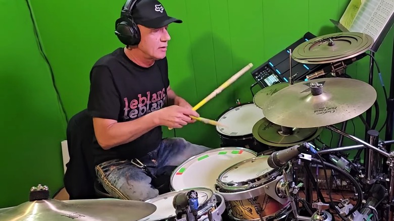Keith LeBlanc playing drums in a green room