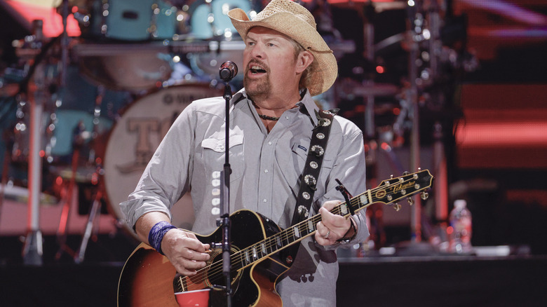 Toby Keith playing guitar onstage