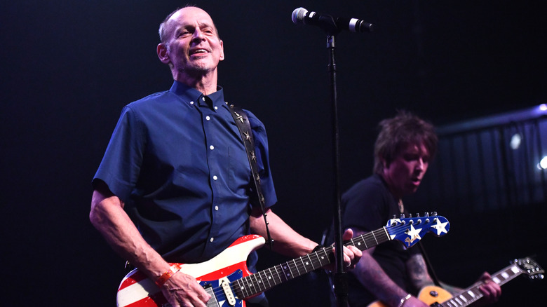 Wayne Kramer smiling holding a guitar onstage