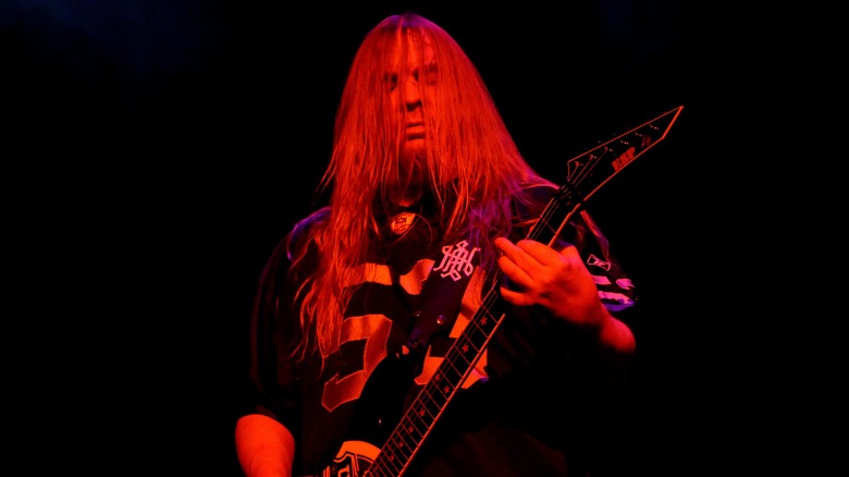 Jeff Hanneman playing guitar under red lighting onstage