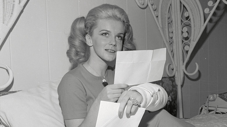 Ann-Margret reads a letter with her left arm in a cast