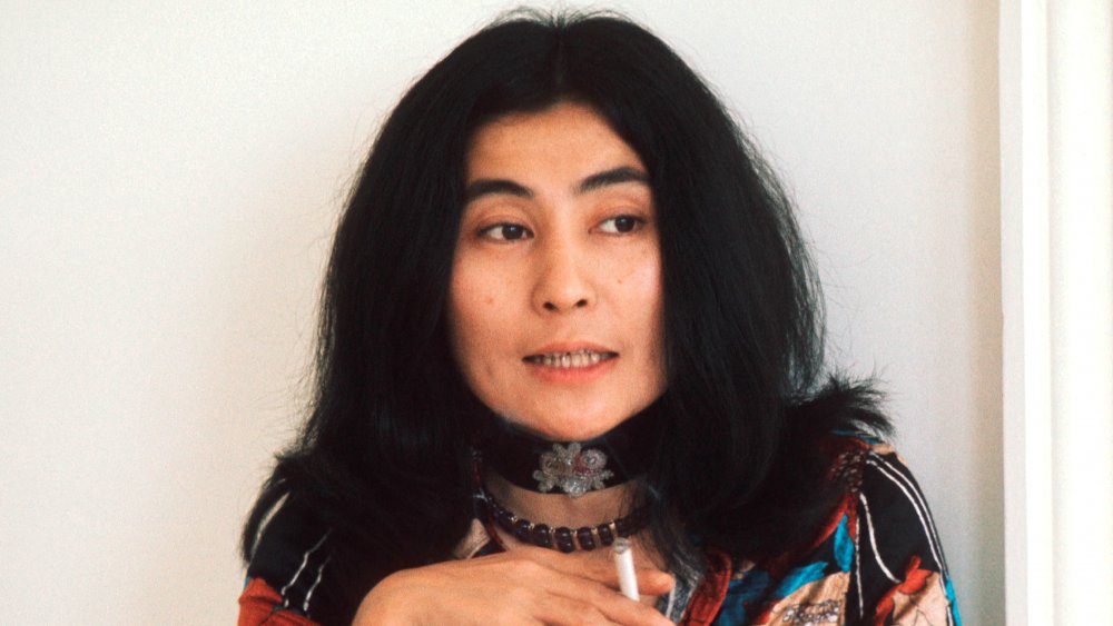 Yoko Ono holding cigarette smiling