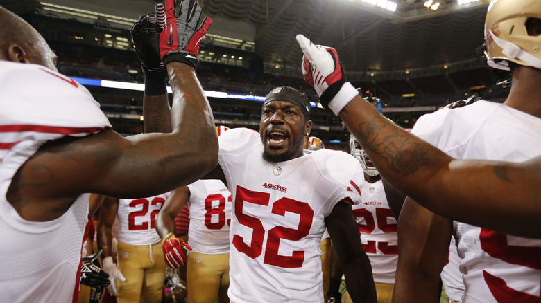Patrick Willis cheering white number 52 jersey with teammates
