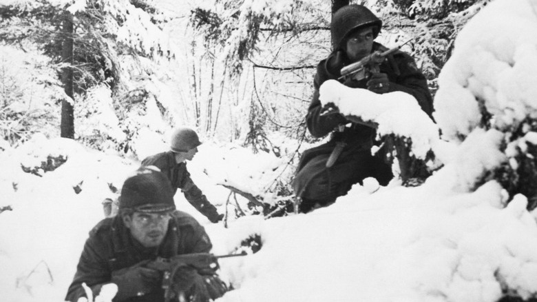 WWII soldiers crouching in snow