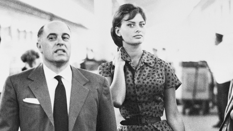 Carlo Ponti and Sofia Loren walking through an airport