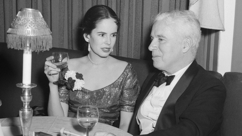 Charlie Chaplin and Oona O'Neil drinking at a small table