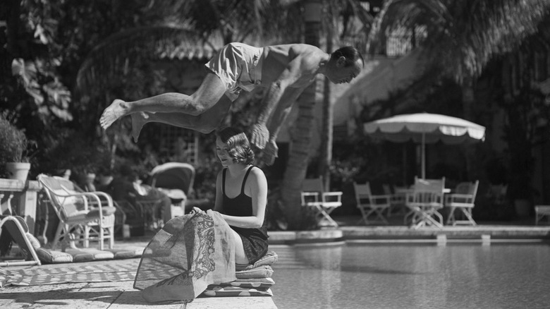 Douglas Fairbanks Sr. diving over Sylvia Ashley into pool