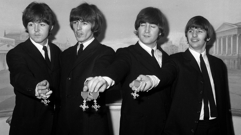 Beatles posing with MBE medals