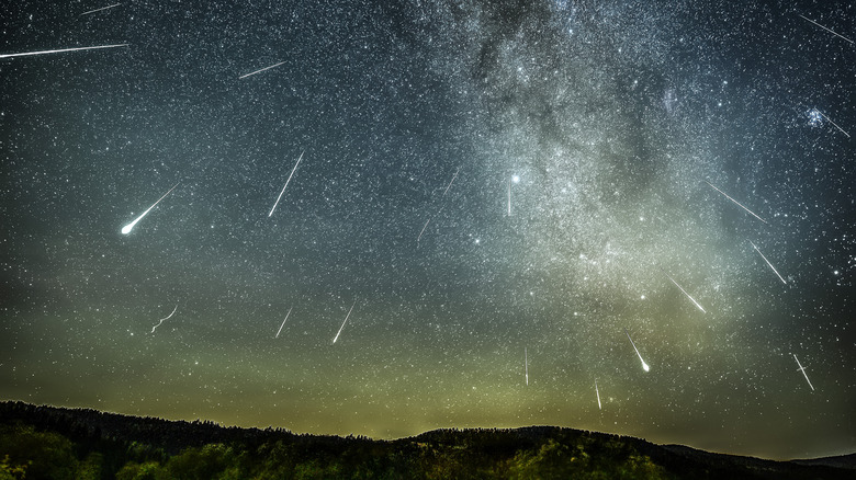 Meteor shower in the night sky, with the Milky Way in the background
