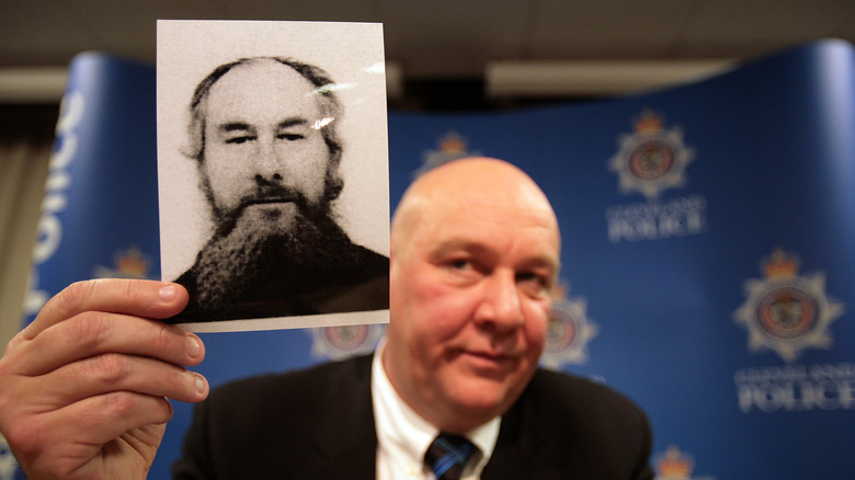 Policeman holding up a photo of John Darwin