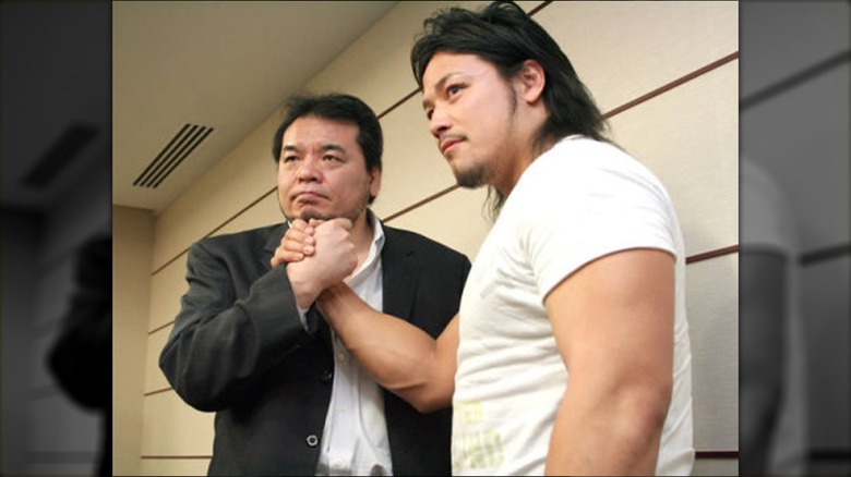 Mitsuharu Misawa suit shaking hands