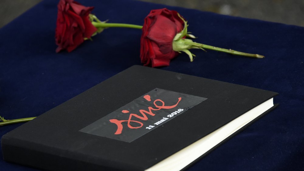 two red roses near a book of condolences for cartoonist Sine