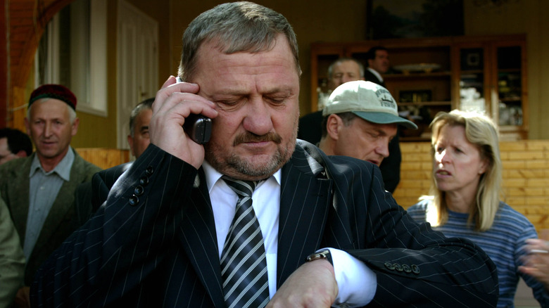 Akhmat Kadyrov on cell phone looking at watch