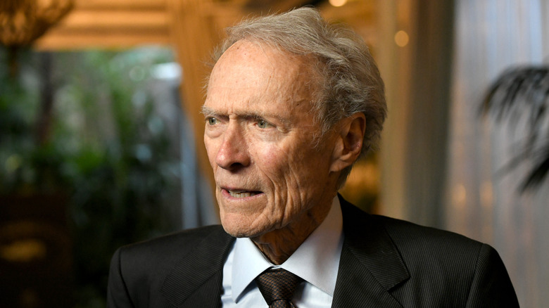 Clint Eastwood in black suit looking to his right