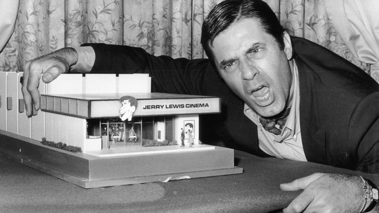 Jerry Lewis leaning on cinema model with mouth open