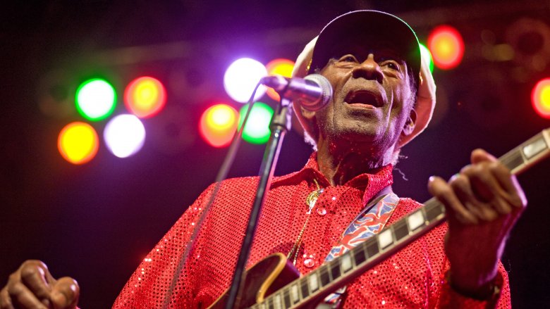 Chuck Berry playing guitar red shirt hat