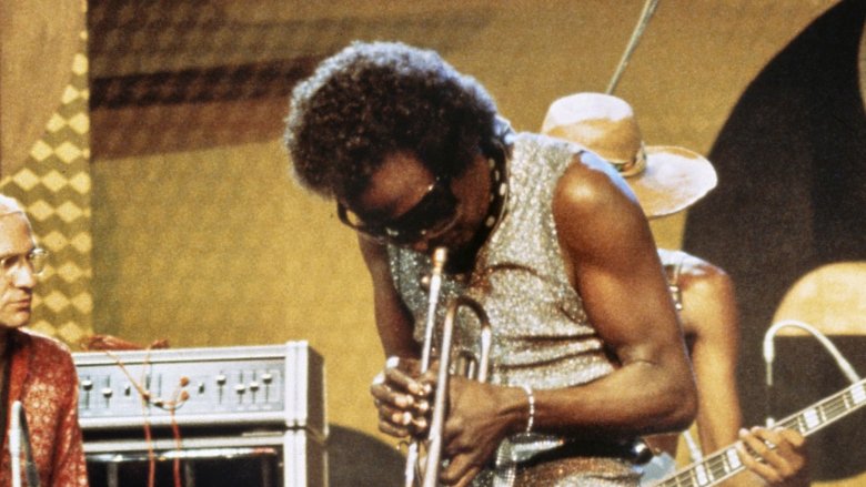 Miles Davis playing trumpet on stage sunglasses
