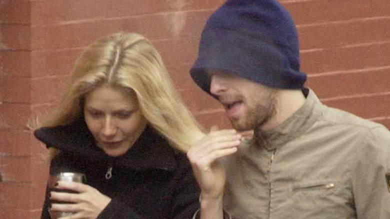 Chris Martin hat and Gwyneth Paltrow walking outside