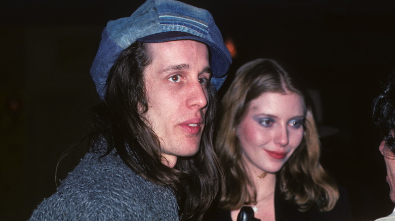 Todd Rundgren blue hat and Bebe Buell on street