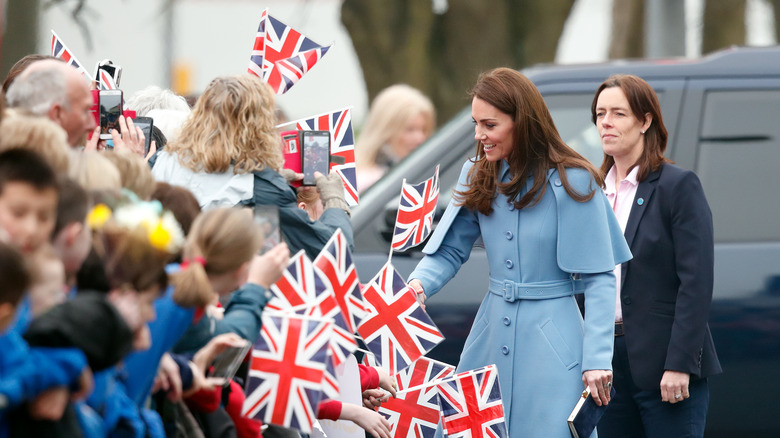 Kate Middleton greets people with bodyguard