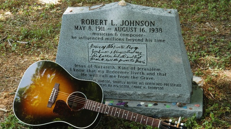 A guitar laying  by Robert Johnson's headstone