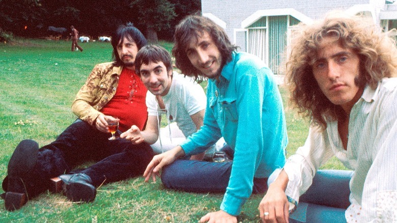 Four members of The Who sitting on lawn smiling