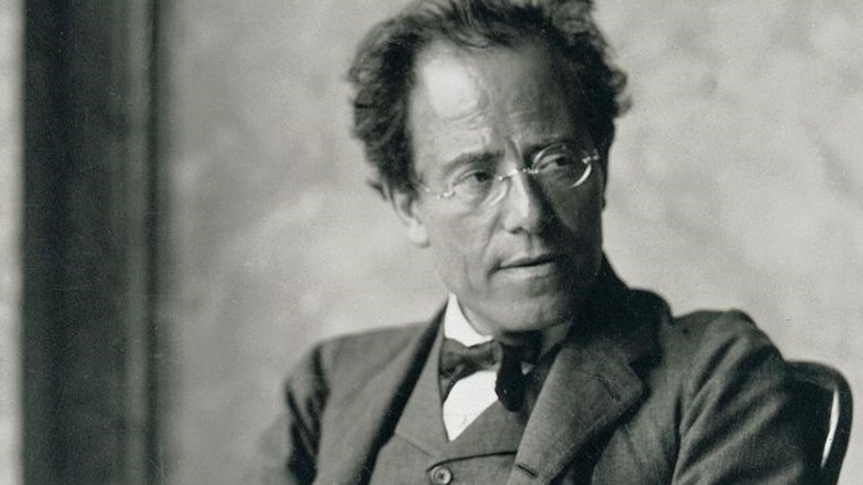 Gustav Mahler glasses suit looking to the side