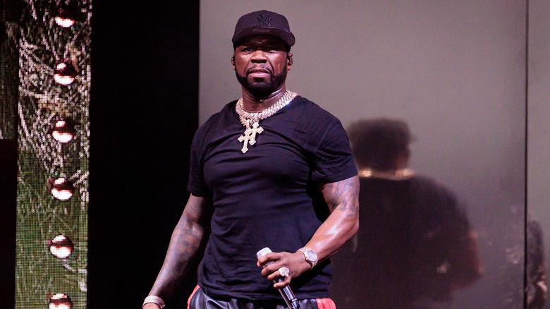 50 Cent holding a microphone onstage