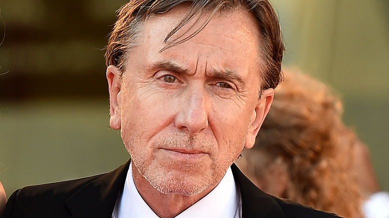 Tim Roth frowning in black suit