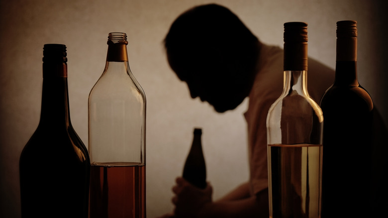 Silhouette of alcoholic with bottles