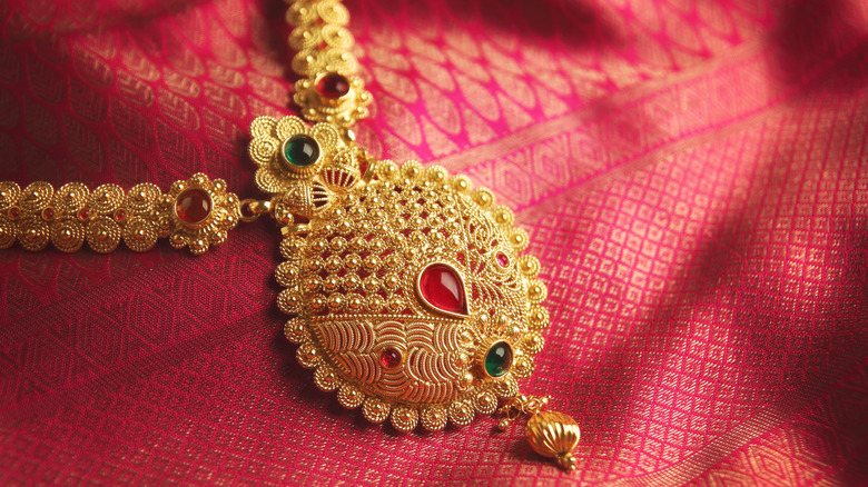 Elaborate gold necklace on red fabric