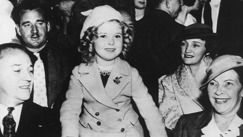 Shirley Temple smiles in a crowd