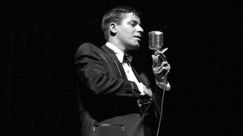Jerry Lewis on stage with microphone and cigarette
