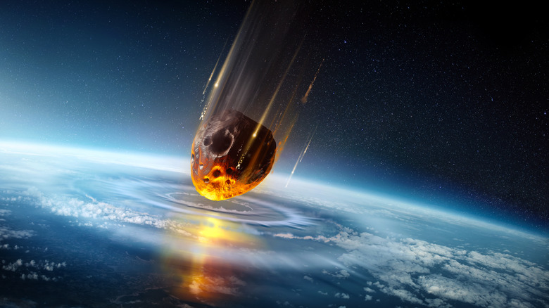 Illustration of asteroid glowing striking earth from space