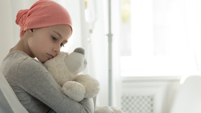 Child in headwrap with a teddy bear
