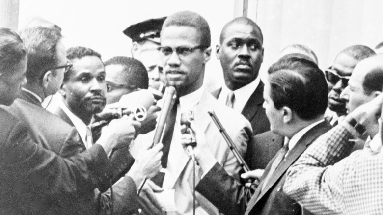 Malcolm X surrounded by reporters
