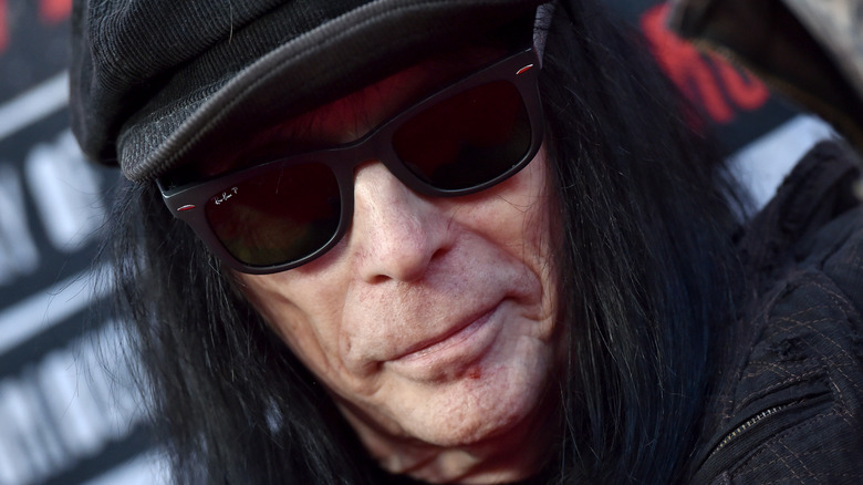 Mick Mars wearing a hat and sunglasses